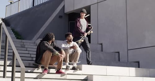 4k video footage of three skaters chatting to each other at the skatepark