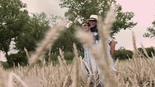 Piggyback. Casually Dressed Heterosexual In-Love Couple Having Fun Together in Field. Steadicam