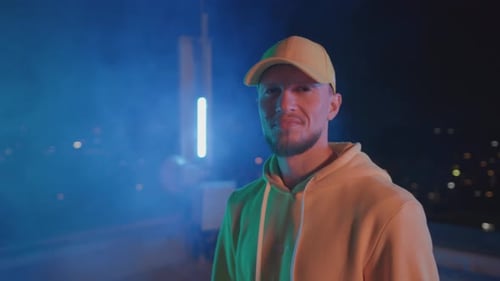 Portraitgesicht eines gutaussehenden Hip-Hop-Künstlers, Tänzer in gelbem Outfit, der vor der Nacht selbstbewusst lächelt