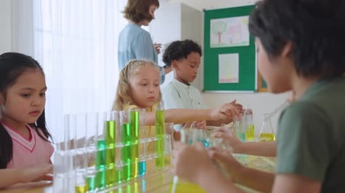 Adorable student learn with teacher in classroom at elementary school.