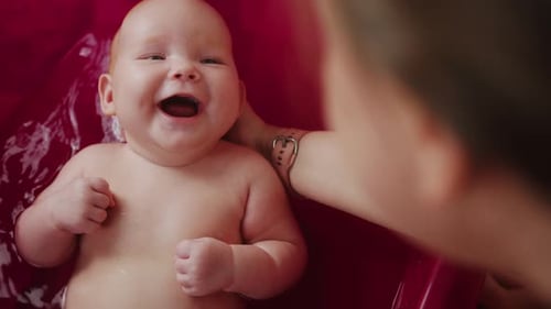 Mother Playing with Her Baby in a Bathtub Shallow Depth of Field