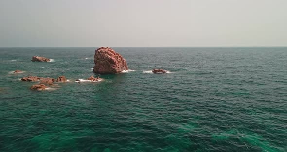 Big Red Rocks With White Waves Crashing In The Ocean Of Sardinia, Italy ...