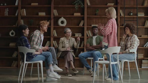 Six Adults Participate in Group Discussion in Library