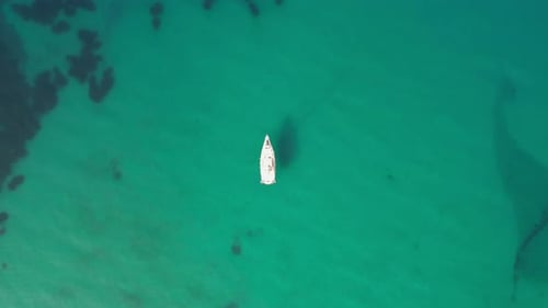 Beautiful aerial view of a white yacht and a clear azure sea.