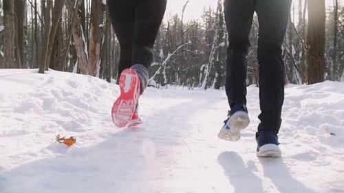 Young Man and Woman Running in Winter Forest Morning Snow
