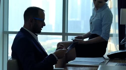 Young businesspeople talking and using tablet computer in modern office
