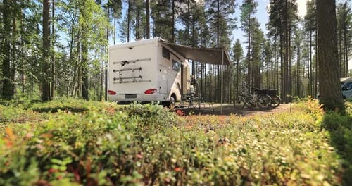 Campervan Parked in Sunny Forest with Bicycles