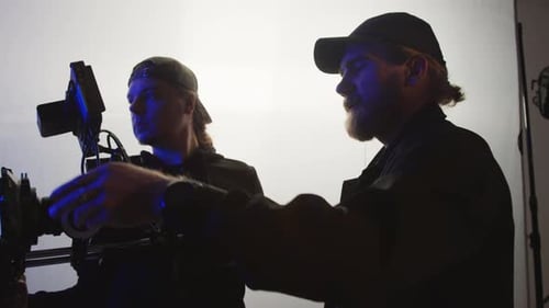 Videographer and Assistant Getting Ready for Fashion Shoot in Studio