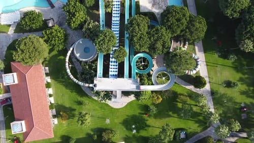 colorful waterslides and swimming pool in the forest with aerial drone 4k