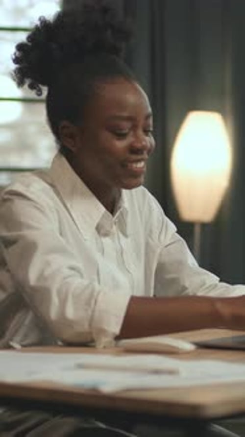 View on African American Business Woman Sitting on Chair Use Laptop in Light Office Smiling Feel