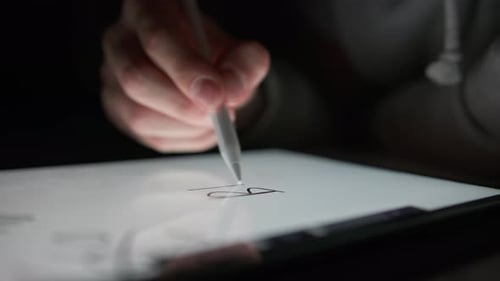 Hand Using Stylus to Draw on Tablet