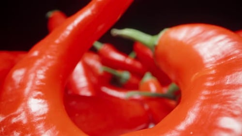 Red hot pepper, scattered on the table, on a black background. the camera passes through the peppers
