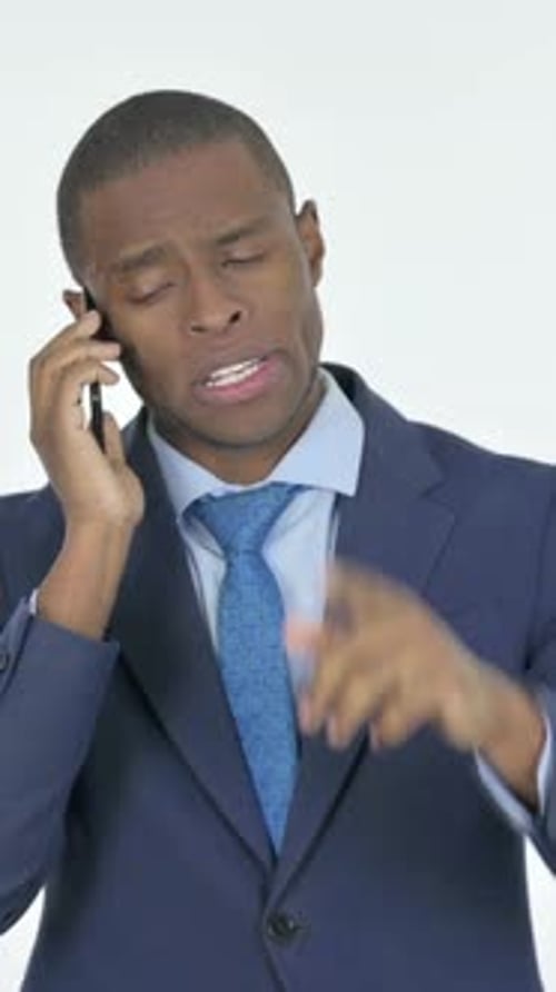 Serious Man in Suit Talking on Smartphone