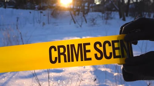 Backlit Crime Scene Tape Unrolling in Snowy Forest at Winter Sunset