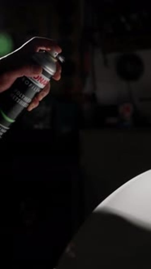 A Person is Spraying a Can of Polyurethane Onto a Surface