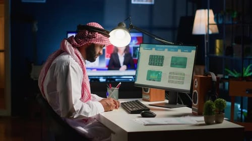 Man Works at Computer Desk at Night