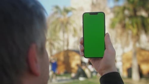 Young Man Holding Phone Chroma Key Screen on the Street Closeup Male with Green Screen on Smart