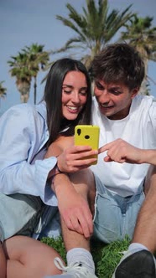Smiling Couple Watching Phone in Tropical Urban Setting