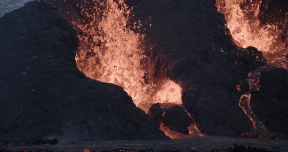 Exploding magma from basalt rock crater at volcano in Iceland at night ...