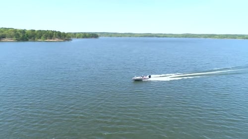 Speedboat races across serene lake water in beautiful mountain landscape view