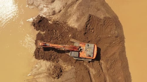 Excavatrice opérant dans le cadre d'une construction d'urgence d'une barrière anti-inondation, images aériennes de haut