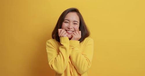 Smiling woman in yellow against matching backdrop