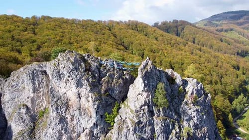 Vista aérea de escaladores relajándose en hamacas azules en la cima de una montaña, Baia De Fier, Romani