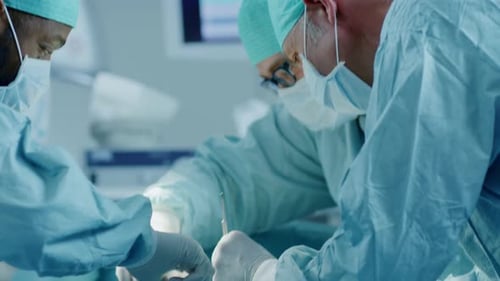 Equipe diversificada de cirurgiões profissionais realizando cirurgia invasiva em um paciente no Hospital Oper