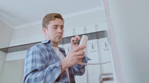 Experienced low-voltage specialist adjusts the intercom for smooth operation and user convenience.