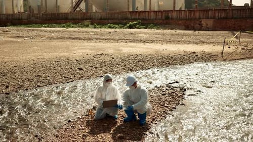 Scientists Analyzing Water Quality Near Industrial Area