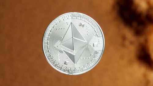 Silver Ethereum Coin Slowly Disintegrates Into Small Particles Against a Striking Gold and Black