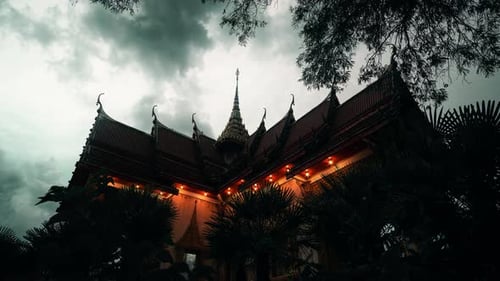 Timelapse of Dramatic Clouds Over Wat Chalong Temple in Phuket at Dusk with Temple Lights