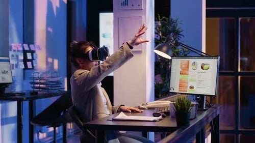 Woman Using VR Headset in Modern Office at Night