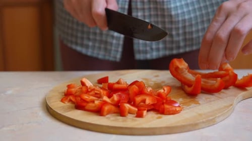 Slicing Red Bell Pepper on a Wooden Cutting Board