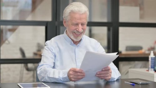 Man Looks at Document and Celebrates Success