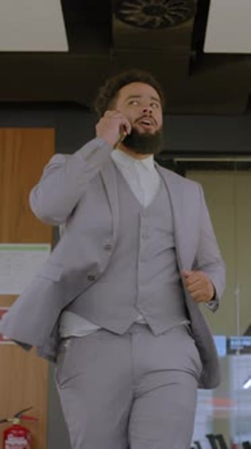 Young Adult Man in Suit Talking on Phone in Office