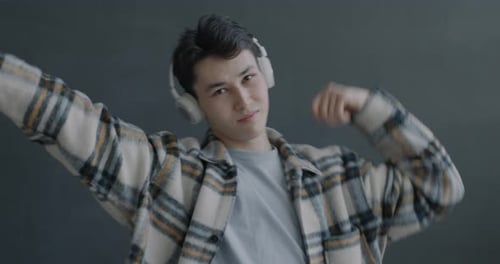 Young Man Listening to Music and Dancing Indoors