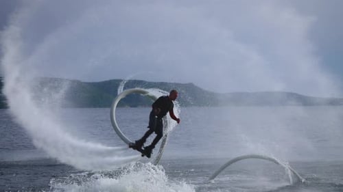 Flyboard a New Extreme Sport A Man a Flyboarder Performs Flips Over the Water An Agile and Trained