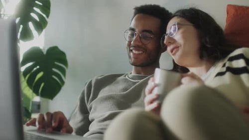 Affectionate Couple Relaxing at Home with Laptop
