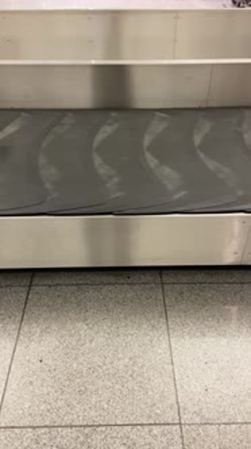 Carrusel de equipaje vacío o cinta transportadora en la terminal del aeropuerto. Cinturón giratorio al que le faltan bolsas y traje