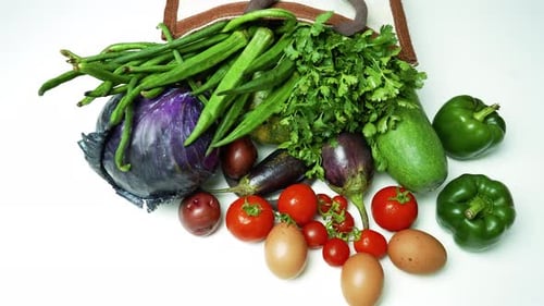 Verduras frescas en bolsa reutilizable, una variedad de verduras frescas que salen de una bolsa reutilizable