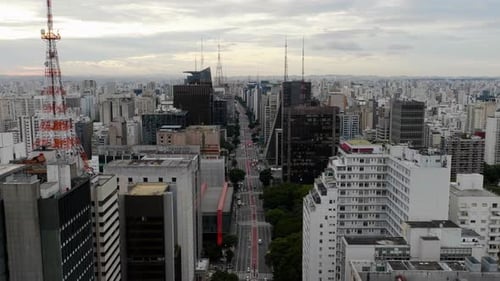 Vista aérea seguindo a Avenida Paulista, noite nublada em São Paulo, Brasil