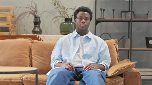 Young Adult Relaxing on Couch at Home
