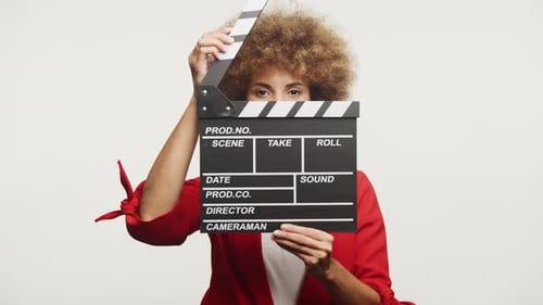 Woman Looking Through Clapperboard Against White Background