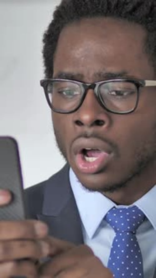 Surprised Man in Suit Reacts to Smartphone