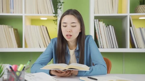 Smiling Student Studying with Book at Desk