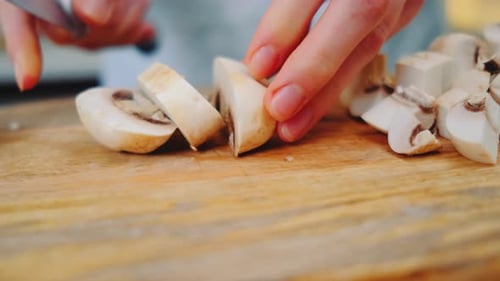 Slicing Mushrooms on Wooden Board Close Up