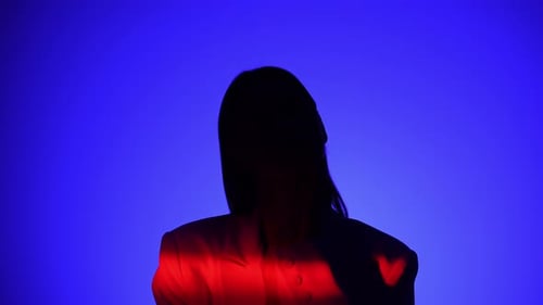 Une personne mystérieuse avec un effet de lumière bleu et rouge spectaculaire