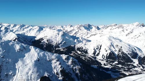 High Altitude Aerial Journey Showcasing Glistening Mountain Ridges And Shadowed Valleys In Bright