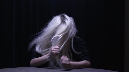 Young Woman Shaking Head with Flying Blonde Hair